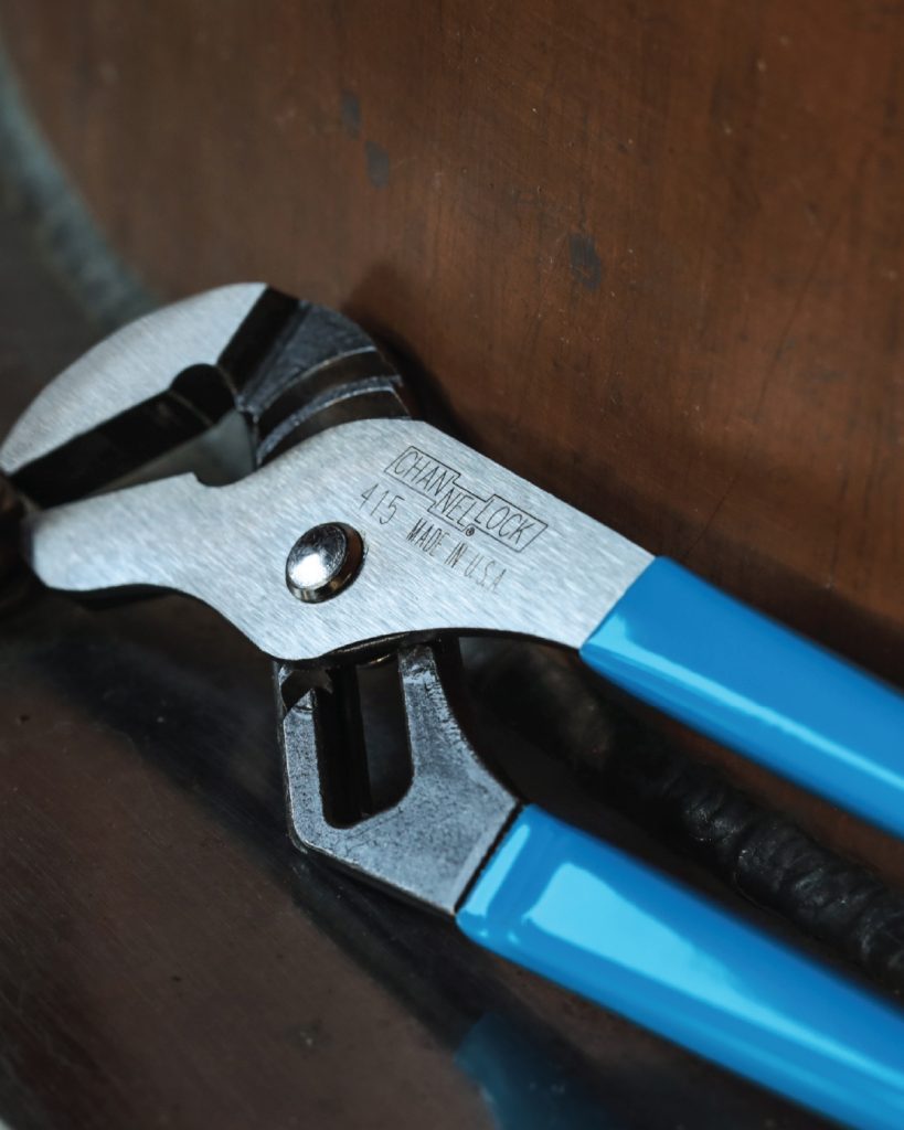 CHANNELLOCK® adjustable pliers with blue handles on a wooden surface.